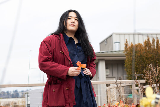 Asian American trans woman standing outside.