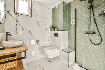 a modern bathroom with green tiles and white marble flooring on the walls, along with a wooden...