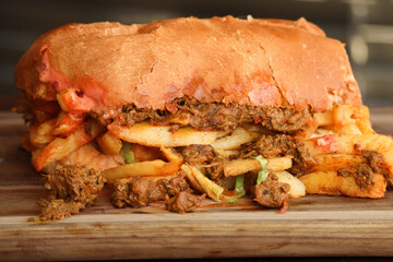 Masala steak Gatsby. Traditional South African fast food with steak and hot chips on a large roll 