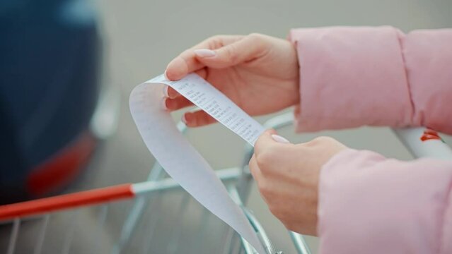 shopper checks paper receipt . calculating money