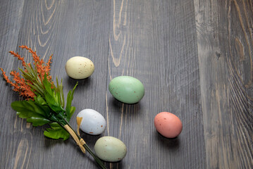 Easter eggs and spring flowers on wooden board with copy space.