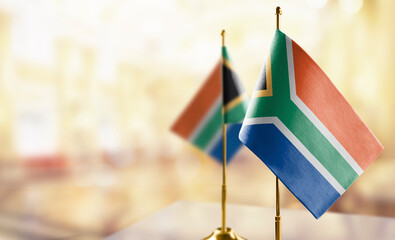 Small flags of the South Africa on an abstract blurry background