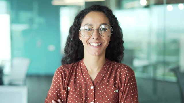 portrait young woman creative employee developer female engineer university teacher or student look at camera smiling in modern office Curly brunette business woman worker in glasses indoor closeup