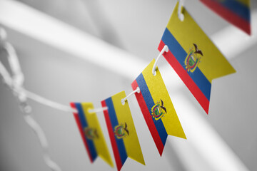 A garland of Ecuador national flags on an abstract blurred background