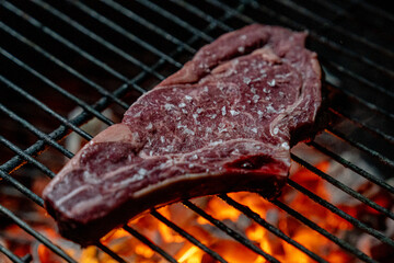 Chuleta de vaca madurada cocinándose en barbacoa de brasas
