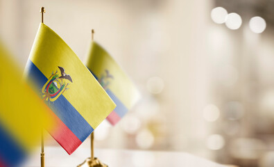 Small flags of the Ecuador on an abstract blurry background