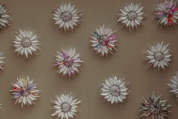 Snowflakes and flowers made of paper close-up view from above DIY on beige background. Children's paper crafts, New Year and Christmas decor, gift for holiday, decoration for Christmas tree