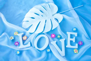 Zelfklevend Fotobehang LOVE"の文字とリボンとオーガンジーとカラフルなプルメリアのデザイン（オーガンジー・水色の背景） © HanaPhoto