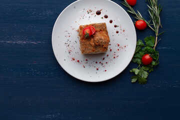 meat dish decorated with tomatoes and herbs