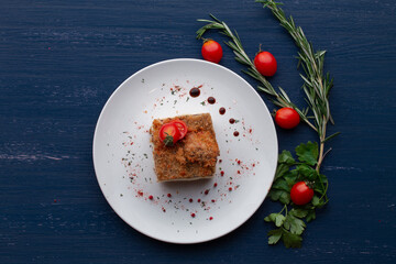 meat dish decorated with tomatoes and herbs