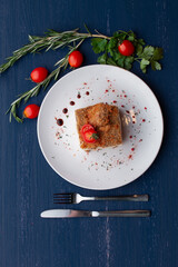 meat dish decorated with tomatoes and herbs