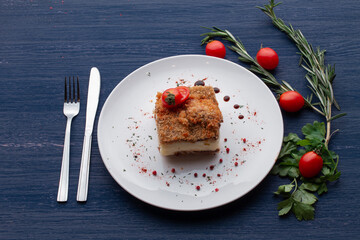 meat dish decorated with tomatoes and herbs