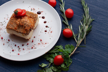 meat dish decorated with tomatoes and herbs