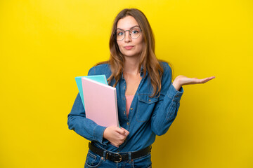 Young student caucasian woman isolated on yellow background having doubts while raising hands