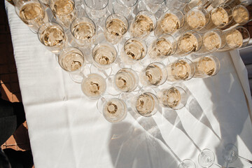 Top view of a lot of wine glasses with a cool delicious champagne or white wine at the bar. Alcohol background.