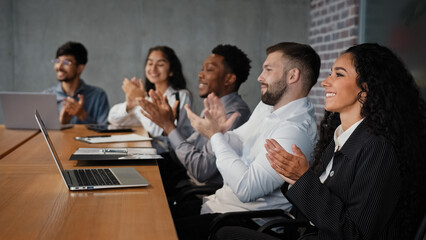 Satisfied multiracial business team partners colleagues workers employees in conference listen project presentation workshop lecture clap hands in meeting applauding corporate success financial growth