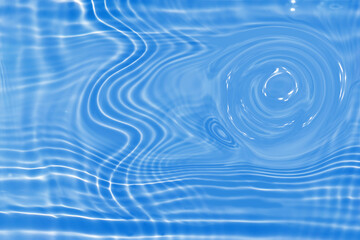 Defocus blurred transparent blue colored clear calm water surface texture with splashes and bubbles. Trendy abstract nature background. Water waves in sunlight with caustics. Blue water shinning 