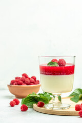 Berry dessert with cream sauce in small jars. Italian dessert. Raspberry Panna cotta with raspberry jelly on a light background. vertical image. top view. place for text