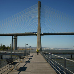 Small man next to a monumental bridge