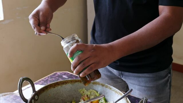 Closeup of black olives being taken out from glass bottle with fork