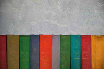 Home library of old battered retro books with colored spines.