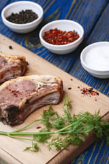 Pieces of raw pork  with spices ,  salt and pepper on blue wooden background in rustic style