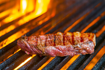 Tasty Beef steaks on the grill with fire flames