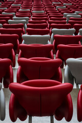 Rows of empty white and red chairs in a football stadium. Anticipation of an upcoming sporting or cultural event.