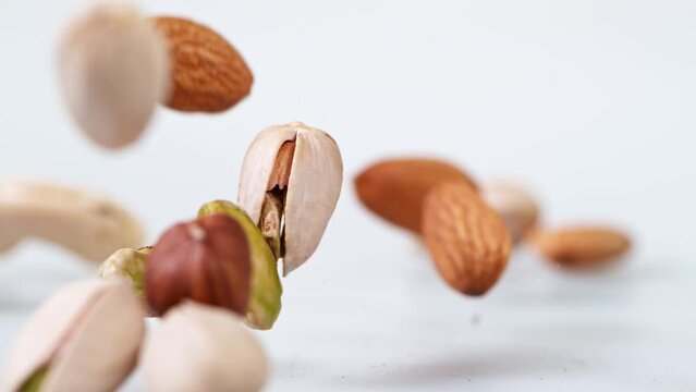 Super Slow Motion Shot of Flying Various Nuts on White Background at 1000 fps.