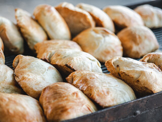 Fresh, hot buns lying on a tray near the hot stove. Sunny, clear day. Close-up, outdoors, no people. Tasty and healthy food concept