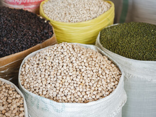 Bags and bowls with fragrant spices lying in the market on a sunny, clear day. Closeup, outdoors, no people. Tasty and healthy food concept