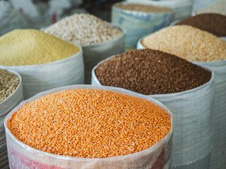 Bags and bowls with fragrant spices lying in the market on a sunny, clear day. Closeup, outdoors, no people. Tasty and healthy food concept