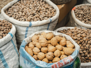 Bags and bowls with fragrant spices lying in the market on a sunny, clear day. Closeup, outdoors, no people. Tasty and healthy food concept