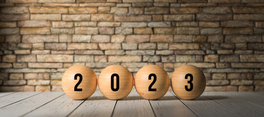 spheres with message 2023 in front of a brick wall background