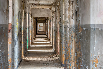 Fototapeta na wymiar Scary abandoned hotel corridor with peeling paint on the walls and ceiling