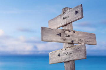 sea la vie text quote on wooden signpost crossroad by the sea