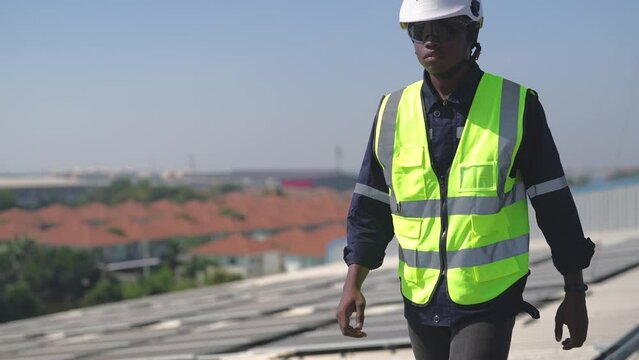 Engineer on rooftop walking next to solar panels photo voltaic check alignment for good installation
