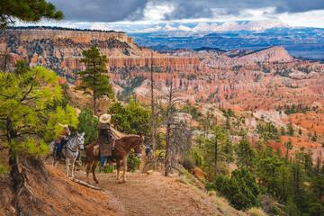 cowboy standing with his horse in bryce canyon