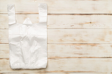Plastic bag on wooden background, top view