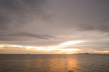 Obraz premium Serene sea and golden cloudscape sky. Warm beach background. Tropical island sunset view. Summer nature.