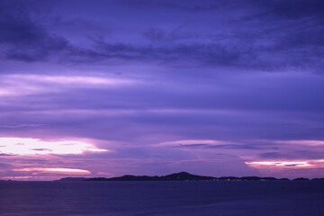 Fototapeta na wymiar Sunset sea and dramatic sky. Twilight and serene beach background. Dusk purple cloudscape. Island evening view.