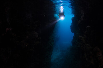 A snorkeler explores a deep, dark grotto, called Leru Cut, in the Solomon Islands. This beautiful, biodiverse area is popular as a snorkeling and scuba diving destination.
