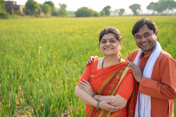 Indian farmer standing with wife at agriculture field. - obrazy, fototapety, plakaty