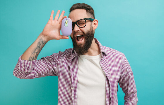Young bearded charismatic hipster advertises a bright wireless computer mouse. Product presentation