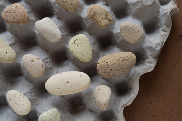 edge of an old egg carton with stone balanced on top