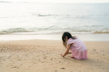 A joyful and playful shot of a young child having fun on the beach, with sand and waves in the background. 