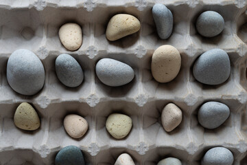 smooth, rounded stones gathered in an old egg carton
