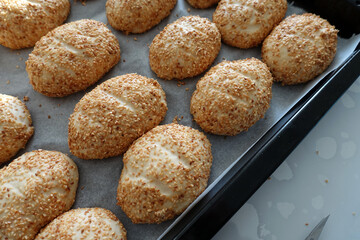 sesame seeds on raw pastry dough, ready-to-bake pastry dough lined up on the tray,