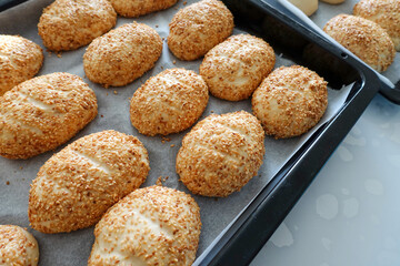 sesame seeds on raw pastry dough, ready-to-bake pastry dough lined up on the tray,