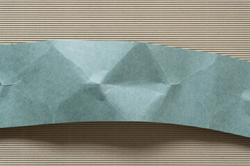 slightly folded and crumpled cut green paper card set horizontally on corrugated paper